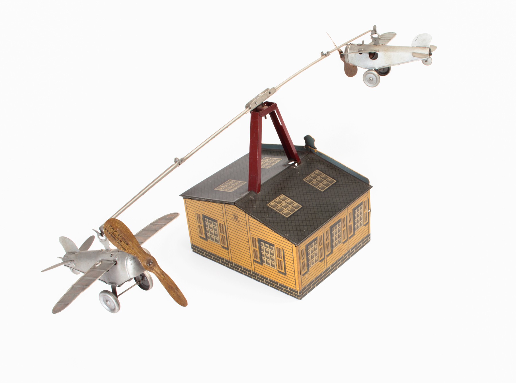 Two planes flying over a hangar